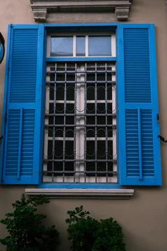 Window with white wooden frames, blue shutters. Image of trendy decor, comfort Stock Photos
