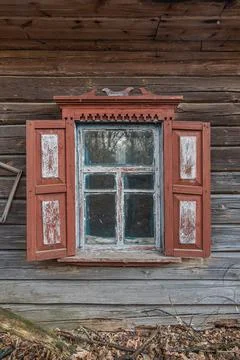 Window with window shutter of an old abandoned wooden house in Chernobyl  Stock Photos