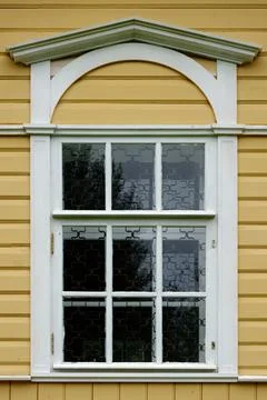 Window on a yellow wall. Stock Photos
