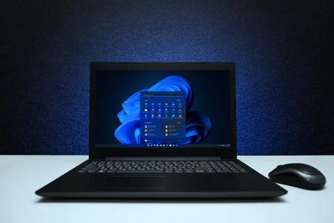 Windows 11 Desktop with logo on the screen laptop computer with mouse on bl.. Stock Photos