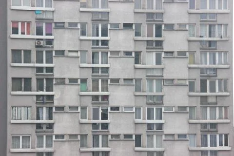 Windows of an apartment building, symmetrical frames in a gray house. many ro Foto stock