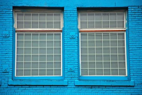 Windows in blue wall Stock Photos