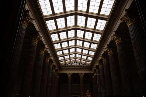 Windows on the ceiling that illuminate the dark room with various columns Stock Photos