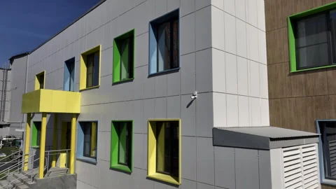 Windows in colored jambs line facade of preschool building Video stock 280915091