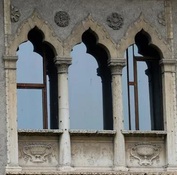 Windows with columns and bas-reliefs on the facade Stock Photos