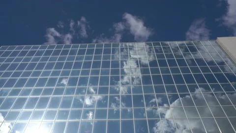 The windows of the glass building of the skyscraper reflect the clouds Stock Footage 125445337