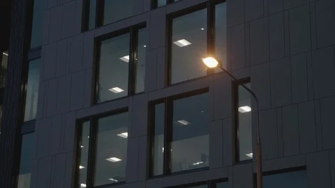 Windows in gray office block with street lamp outside Stock Footage