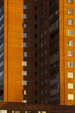 Windows of high building in warm rays of setting sun, urban background Stock-Fotos