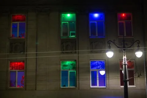 Windows iluminated different colors light in building house at night. Fotos de archivo