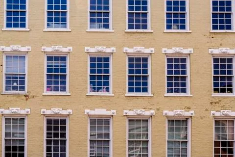 Windows march across the facade of this old brick building Stock Photos