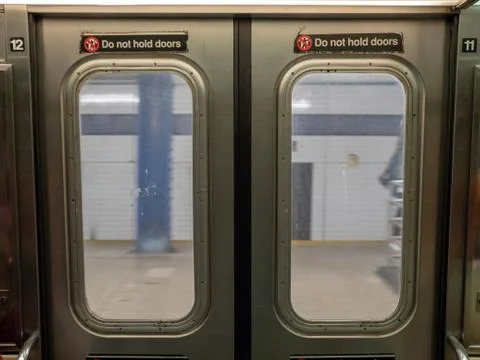 Windows of a moving subway train looking out into station platform upon depar Stock Photos