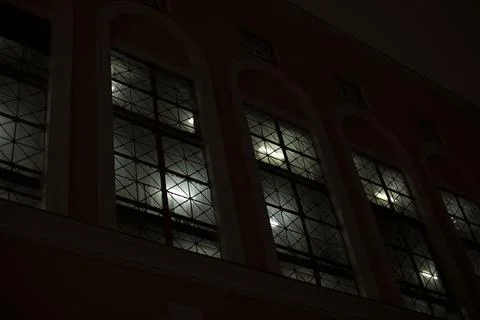Windows at night. Light in windows in evening. Building outside in dark. Stock Photos