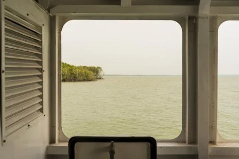 Windows overlooking Can Gio sea on a ferry crossing the sea in Vietnam Stock Photos