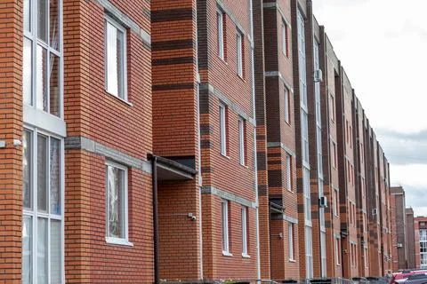 Windows of a residential multi-storey brick house. Modern buildings. Stock Photos