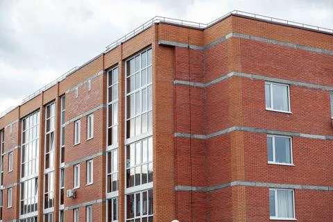 Windows of a residential multi-storey brick house. Modern buildings. Stock Photos