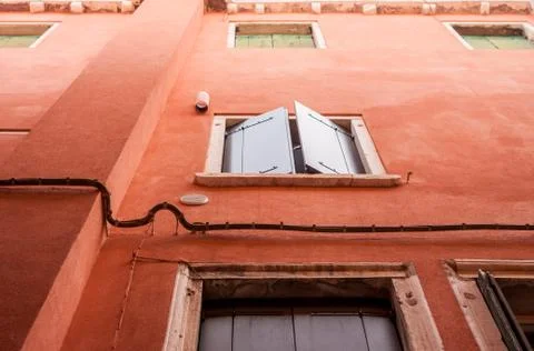 Windows with shutters in red wall Stock Photos
