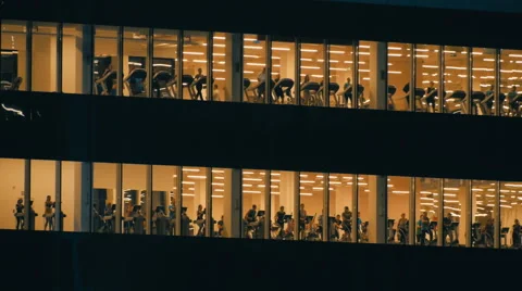 The windows of a skyscraper people training in the gym Stock Footage