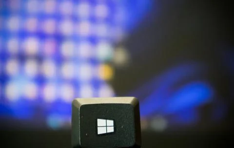 Windows start key picked up from the keyboard and placed in front of a window Stock Photos