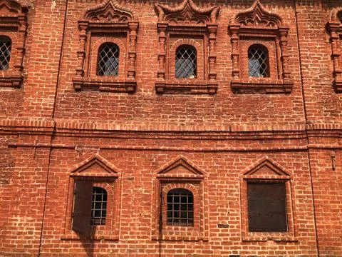 Windows with a stone pattern on the background of a red brick wall Stock Photos