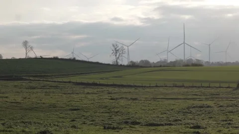 Windpower in front of setting sun in hilly landscape Stock Footage 325721520