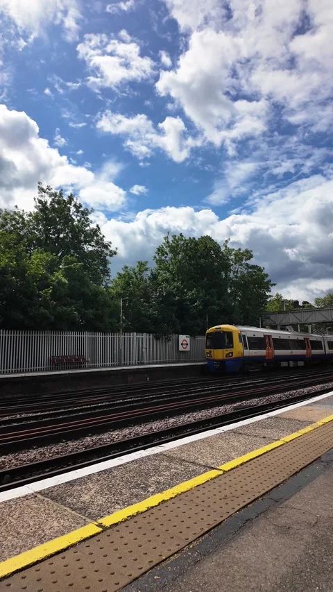 Windrush Line train departing Anerley Station platform under a blue sky with Stock Footage 336036867