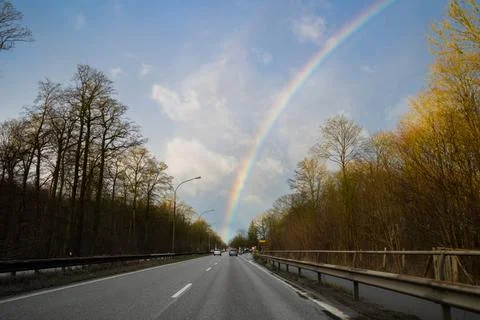 From the windscreen of a moving car you can see a rainbow in the sky Stock Photos