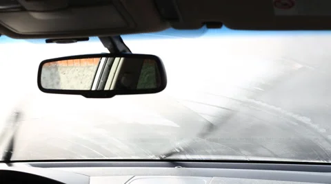 Windscreen wipers cleaning windshield glass on rainy dawn Stock Footage 62113594