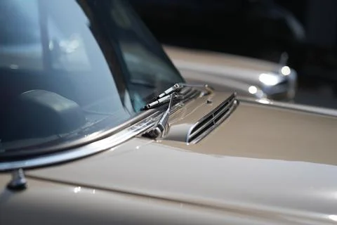 The windshield and chrome wipers of a classic car showcase the timeless all.. Stock Photos