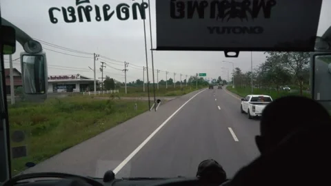 Windshield and dashboard view from inside of bus, driving on highway in thailand Stock Footage 233000646