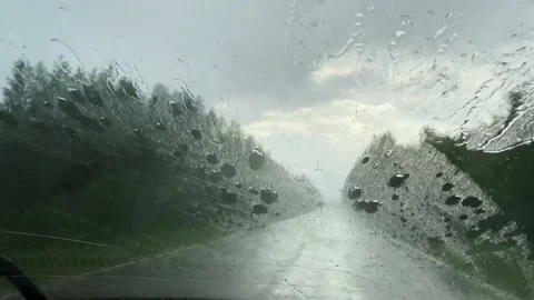 Windshield of a car wet by the rain, wiper blades cleaning the front window Stock Footage 156989398