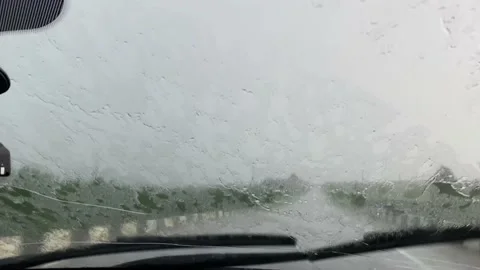 Windshield of a car wet by the rain, wiper blades cleaning the front window Stock Footage 157408952