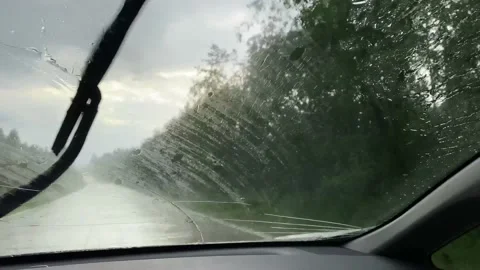 Windshield of a car wet by the rain, wiper blades cleaning the front window Stock Footage 162213806