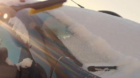 The windshield is covered with a thick layer of snow, which is brushed off with Stock Footage 166819079
