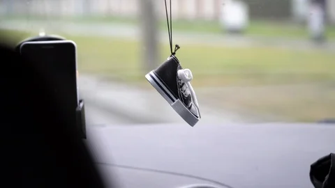 A windshield inside a car with a little sneaker pendant 動画素材 126995322