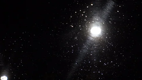 Windshield at night with traffic light in the background focused on rain droplet 스톡 동영상 91376850