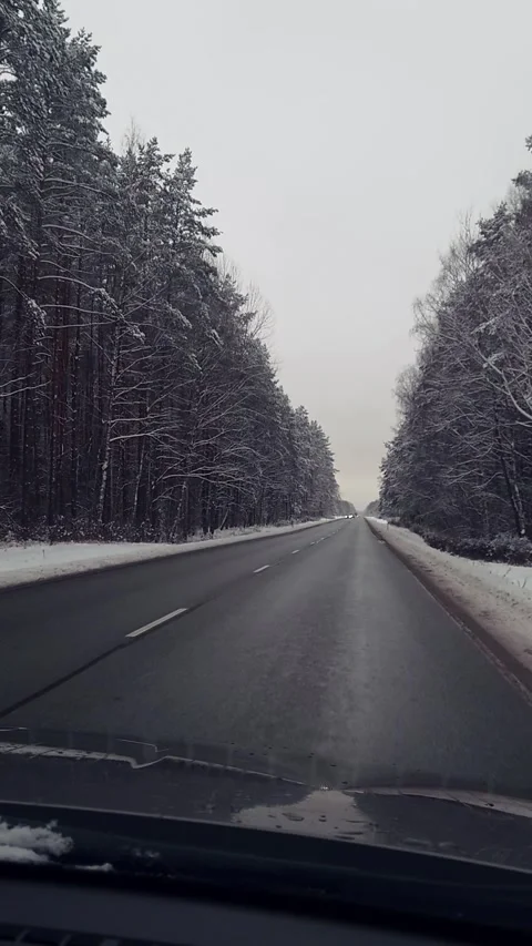 Windshield view of car drives along asphalt road through snowy landscape Vídeo Stock 320971462