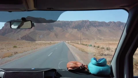 Windshield view of a vehicle driving toward the Atlas Mountains in the desert Stock Footage 336504930