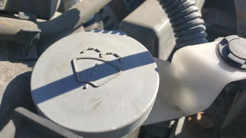 Windshield washer fluid reservoir cap with wiper icon in car engine 库存影片 331273524