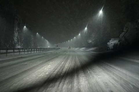 Windshield wiper from the inside of the car in working state while snowing. Stock Photos