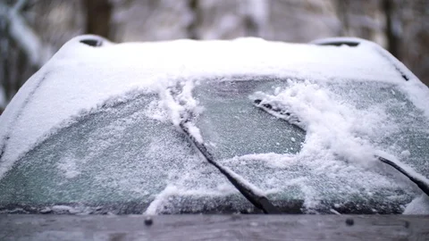Windshield wipers brushing away snow and ice from a car's windshield Stock Footage 121007835