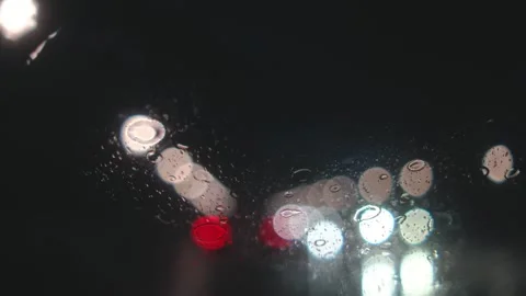 Windshield Wipers Clearing Rain at Night with Blurred City Lights in Background Stock Footage 341756729