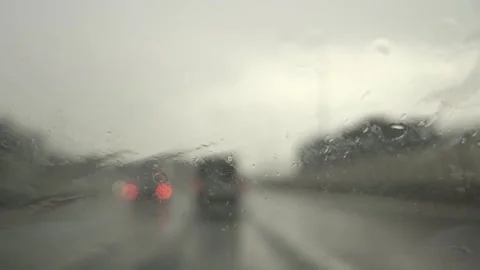 Windshield Wipers Clearing Water Drops with Blurred Traffic Background Stock Footage 327589991