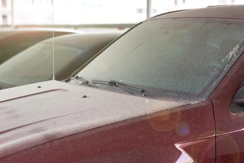 Windshield wipers of a dirty red car covered with a layer of dust. Stock Photos