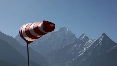 Windsock blowing in wind with Himalaya Mountain peaks in background Video stock 101444715