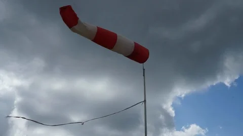 Windsock blowing in the wind infront of grey clouds Stock Footage 100549208