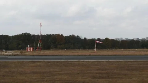 Windsock cone in the gust of wind inside an airport. Cloudy day. Stock Footage 257019378