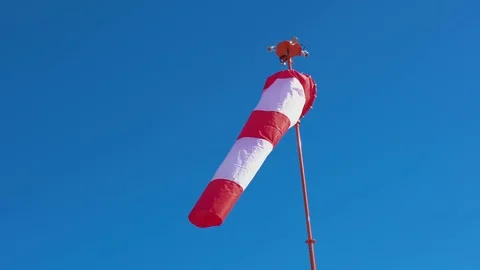 Windsock develops on blue cloudless sky background. 動画素材 106091151