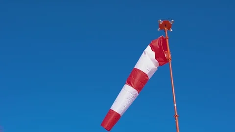 Windsock develops on blue cloudless sky background. Stock Footage 106657729