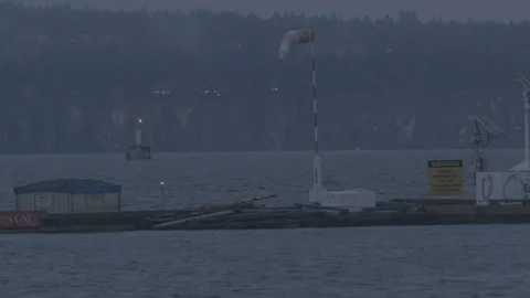 Windsock in harbour blows as light house blinks night Stock Footage 127120349