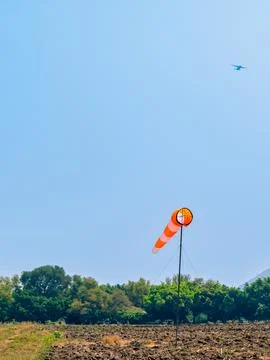 Windsock indicator of wind in meadow with beautiful scenic. Flying windsock.. Stock Photos